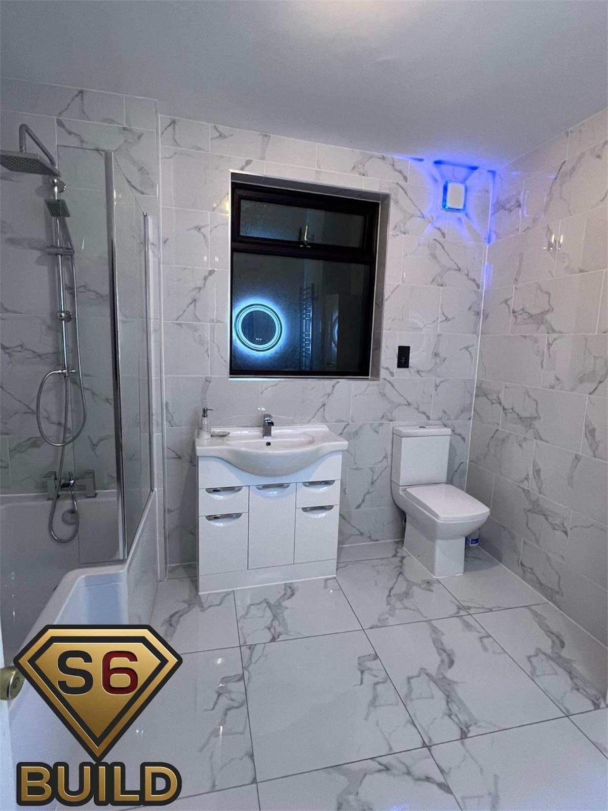 Bathroom refit with tiled walls and coordinated plumbing and electrical work